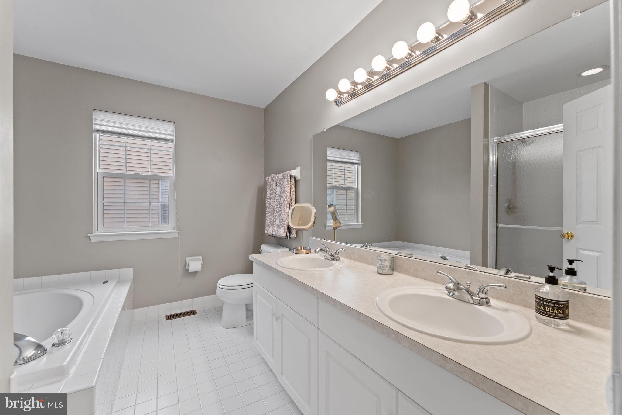 803 Red Coat Road Collegeville, PA 19426 - Photo 20 of 33 a bathroom with a double vanity sink a toilet and a mirror