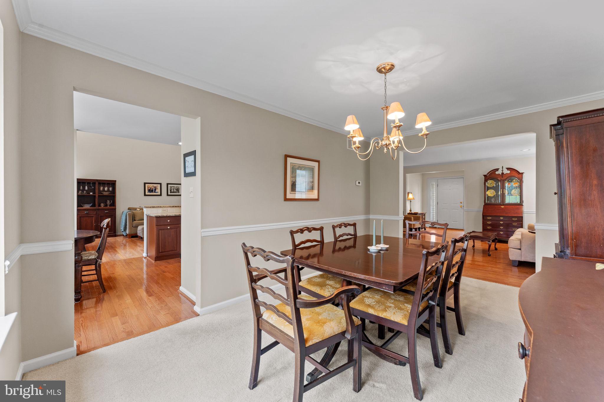 803 Red Coat Road Collegeville, PA 19426 - Photo 8 of 33 a dining room with wooden floor a chandelier a glass table and chairs