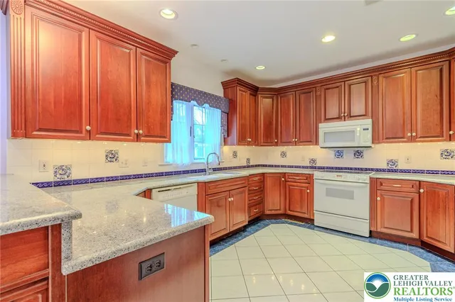 a kitchen with granite countertop wooden cabinets a sink and dishwasher