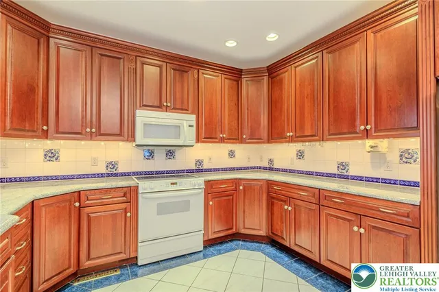 a kitchen with stainless steel appliances kitchen island granite countertop a refrigerator and a stove top oven