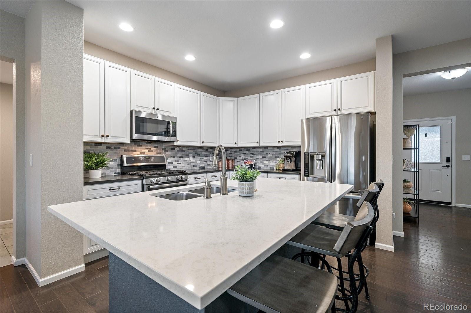 9382 Noble Way Arvada, CO 80007 - Photo 11 of 42 a kitchen with refrigerator and a stove