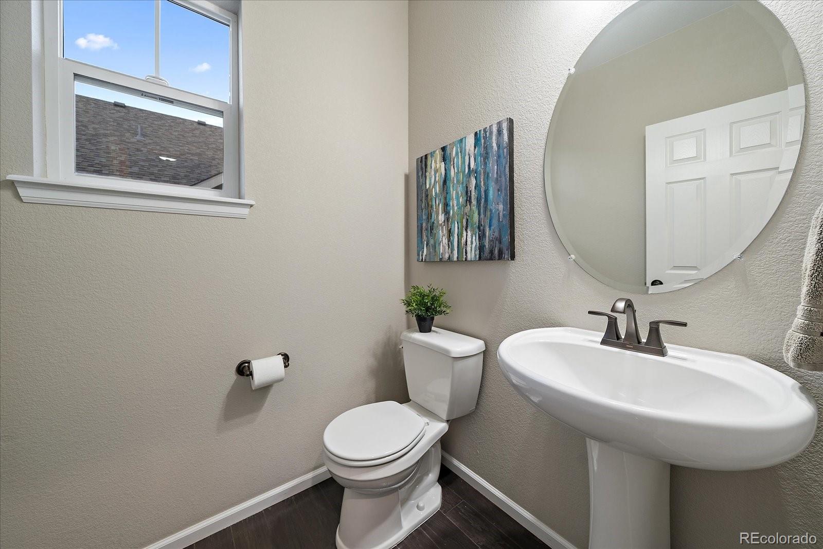 9382 Noble Way Arvada, CO 80007 - Photo 16 of 42 a bathroom with a toilet a sink and mirror