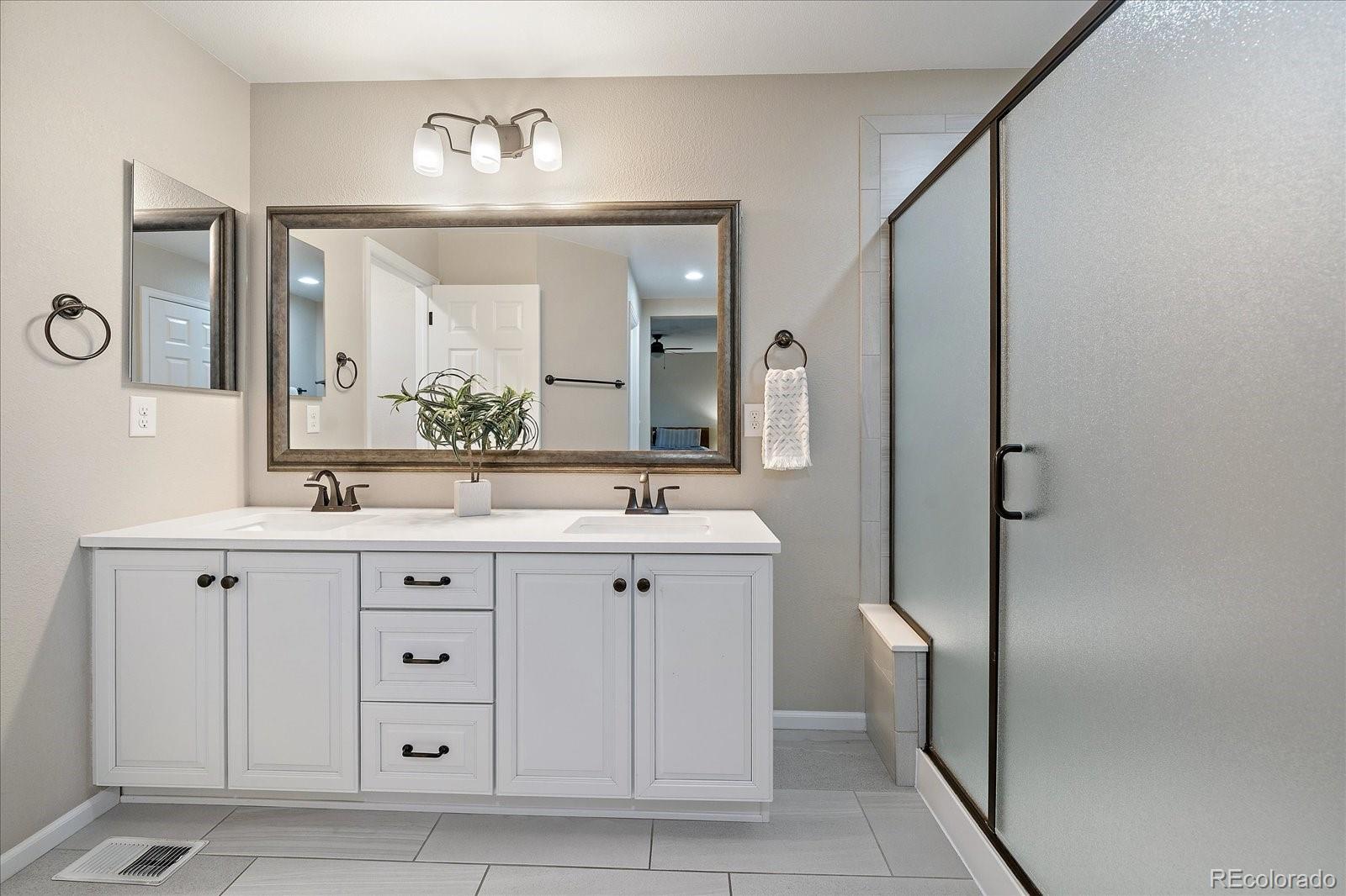 9382 Noble Way Arvada, CO 80007 - Photo 25 of 42 a bathroom with a double vanity sink and a mirror