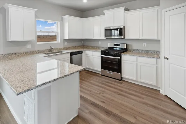 a kitchen with granite countertop white cabinets and white appliances