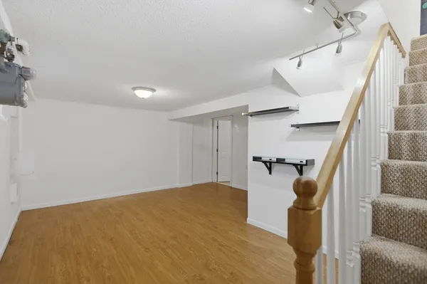 a view of empty room with wooden floor and stairs