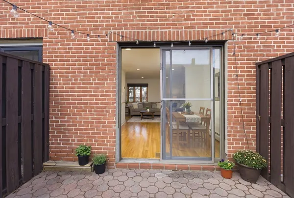 a view of a brick house with potted plants in front of door