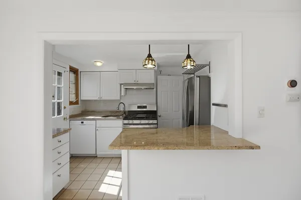 a kitchen with stainless steel appliances granite countertop a sink a stove and a refrigerator