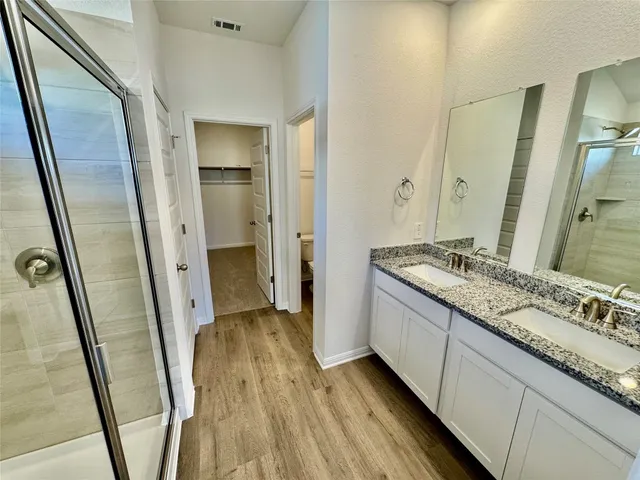 a bathroom with a granite countertop sink a mirror and a shower