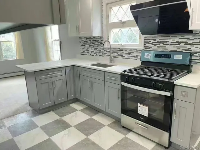 a kitchen with stainless steel appliances granite countertop a stove a sink and a microwave