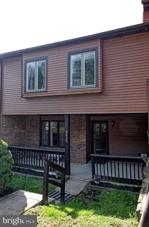 a view of a house with a small yard and wooden fence