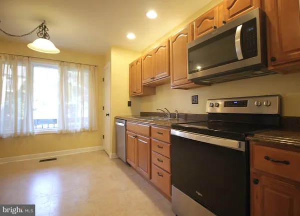 a kitchen with stainless steel appliances granite countertop a sink a stove a microwave oven and cabinets