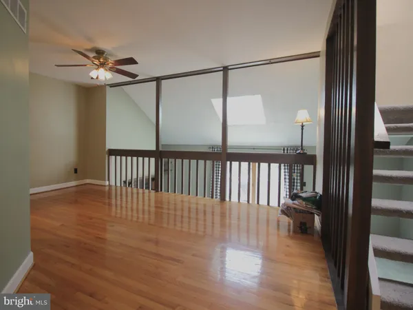 a view of a hallway with wooden floor and a chandelier