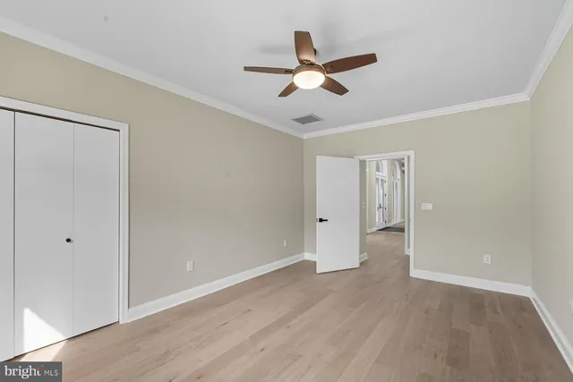 a view of a room with wooden floor and ceiling fan