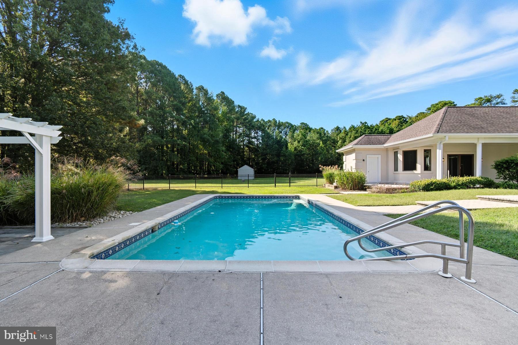 9171 Deepwater Point Road St. Michaels, MD 21663 - Photo 30 of 40 a view of swimming pool with lawn chairs and plants