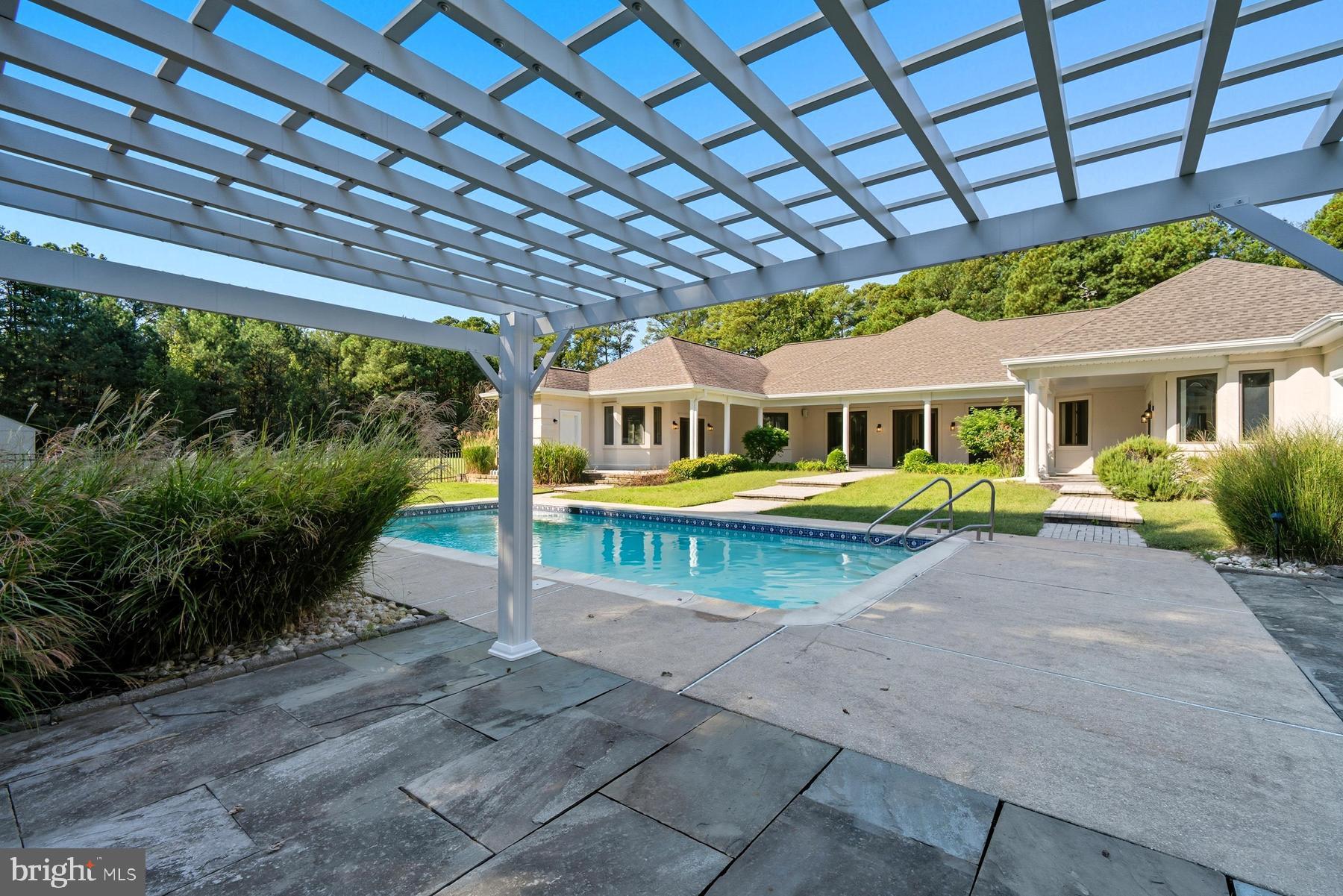 9171 Deepwater Point Road St. Michaels, MD 21663 - Photo 31 of 40 a view of a swimming pool with a patio