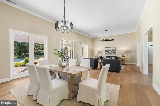 a dining room with furniture a chandelier and wooden floor