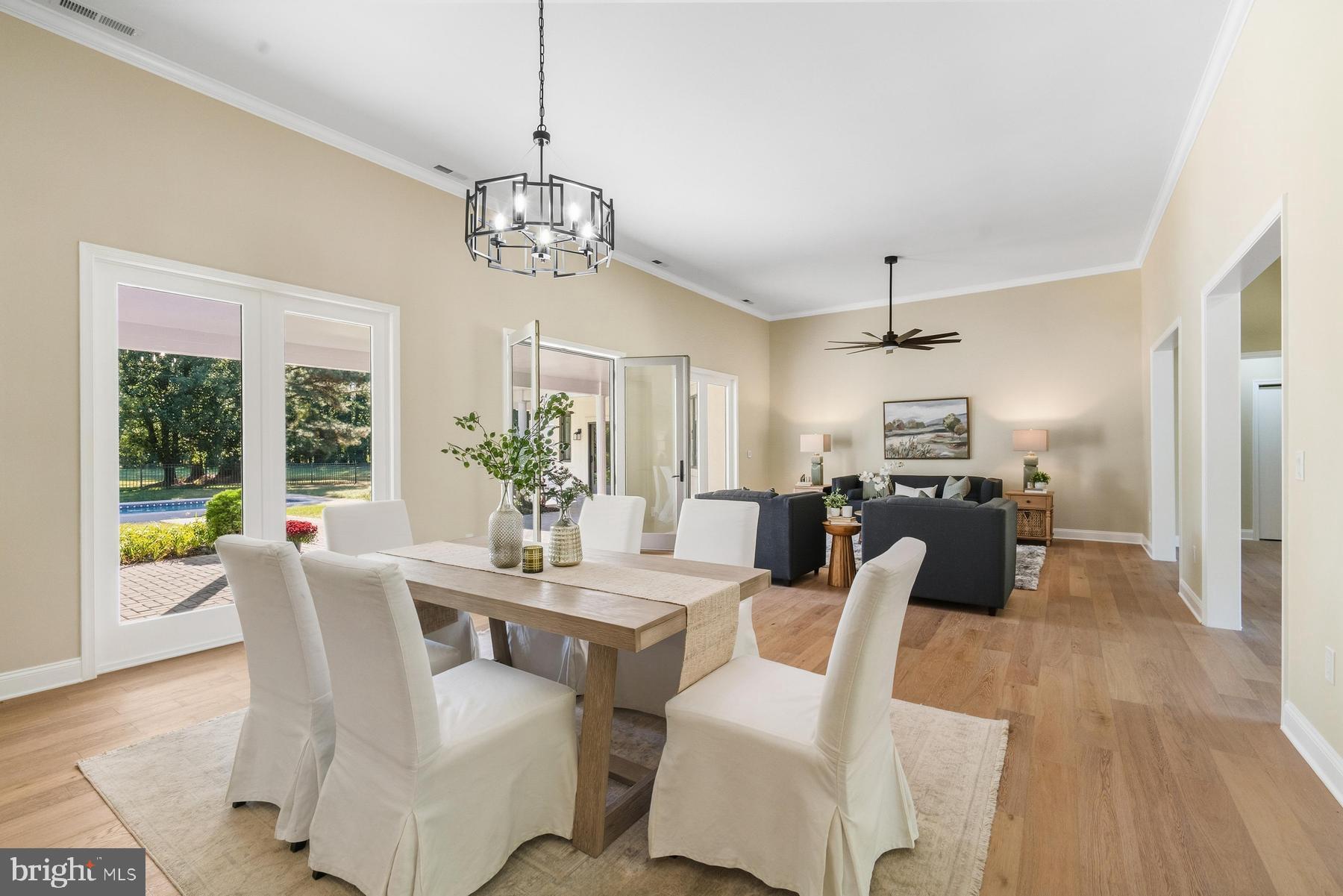 9171 Deepwater Point Road St. Michaels, MD 21663 - Photo 5 of 40 a dining room with furniture a chandelier and wooden floor