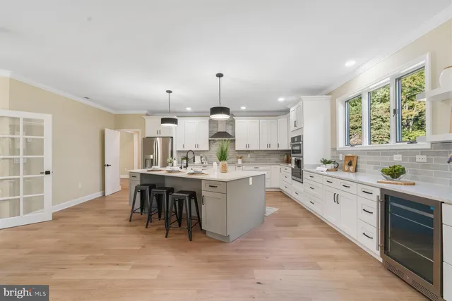 a large kitchen with kitchen island a sink table and chairs