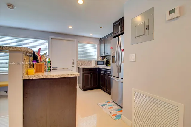 a view of a kitchen with stainless steel appliances granite countertop a refrigerator and a sink