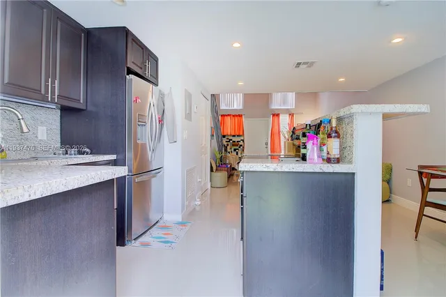 a kitchen that has a refrigerator and a table in it