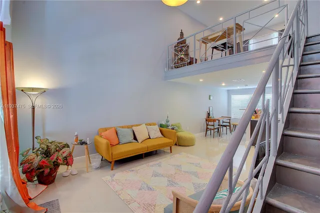 a bedroom with a bed a chair and potted plant on the dresser