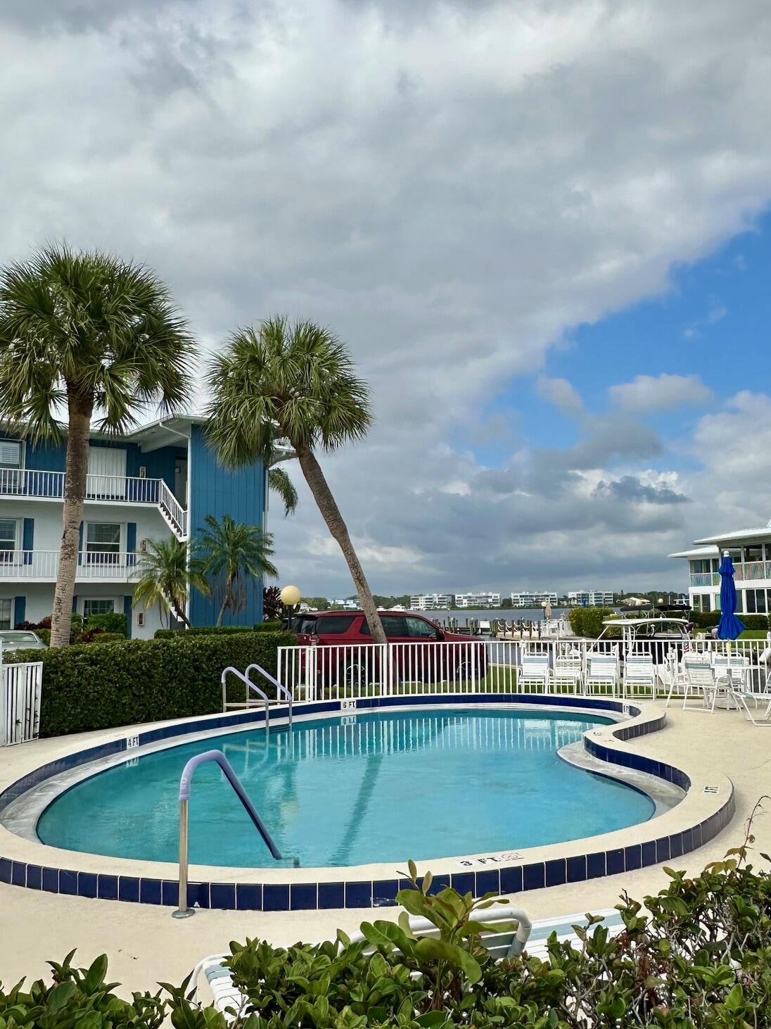 1868 Southwest Palm City Road, Unit 202 Stuart, FL 34994 - Photo 16 of 18 a view of a swimming pool with a yard and plants