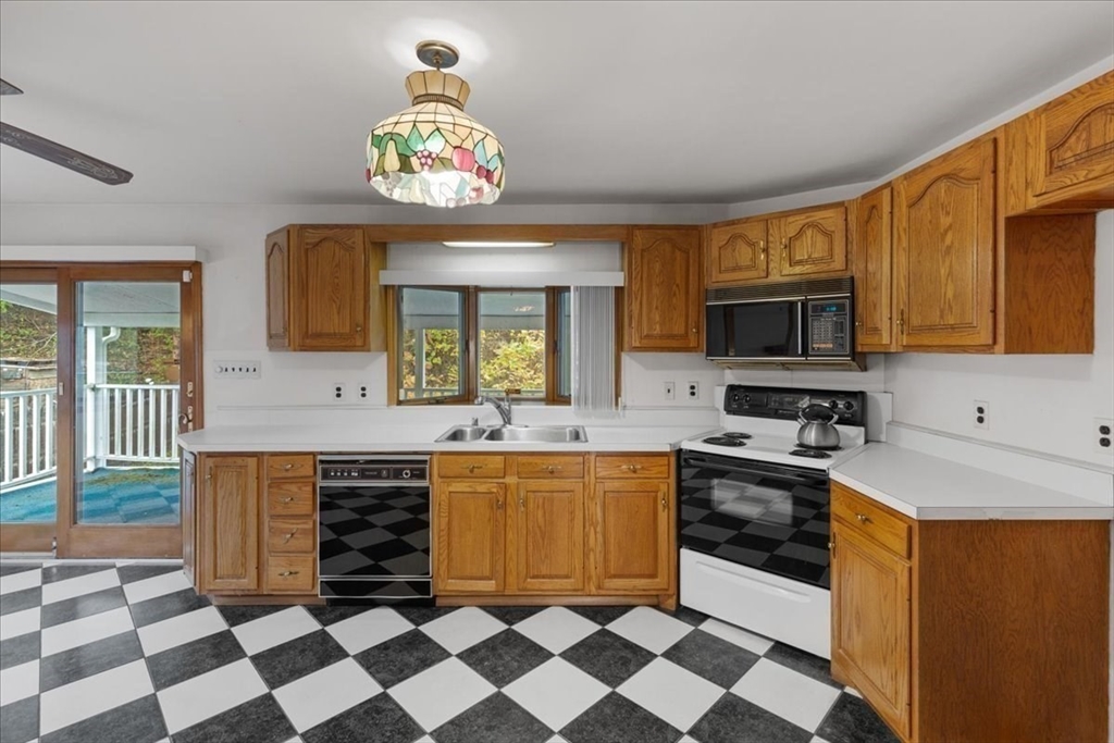 109 Merryknoll Road Weymouth, MA 02191 - Photo 19 of 41 a kitchen with stainless steel appliances a sink a stove a microwave a refrigerator and cabinets