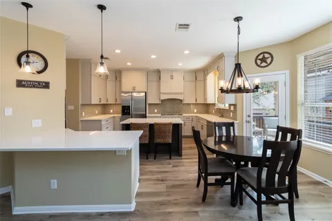 a large kitchen with a table and chairs