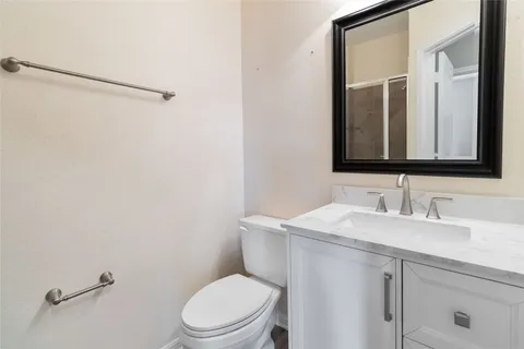 a bathroom with a toilet sink vanity and mirror
