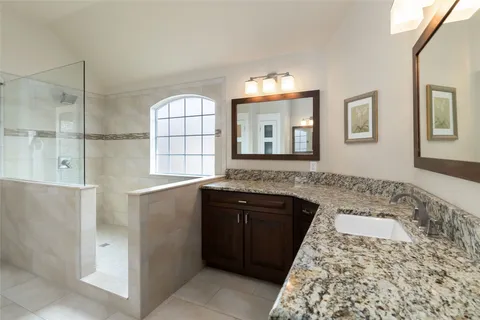 a bathroom with a granite countertop sink a mirror and a bathtub