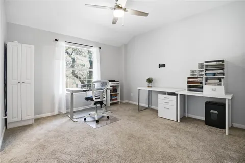 a view of a workspace with furniture and a window