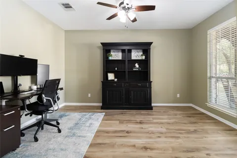 a view of a workspace with furniture and a window