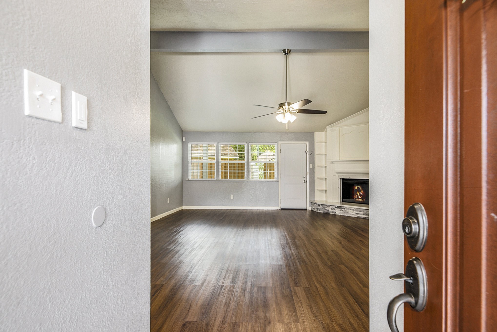 2539 Cobblers Way Friendswood, TX 77546 - Photo 3 of 19 an empty room with wooden floor fireplace and windows