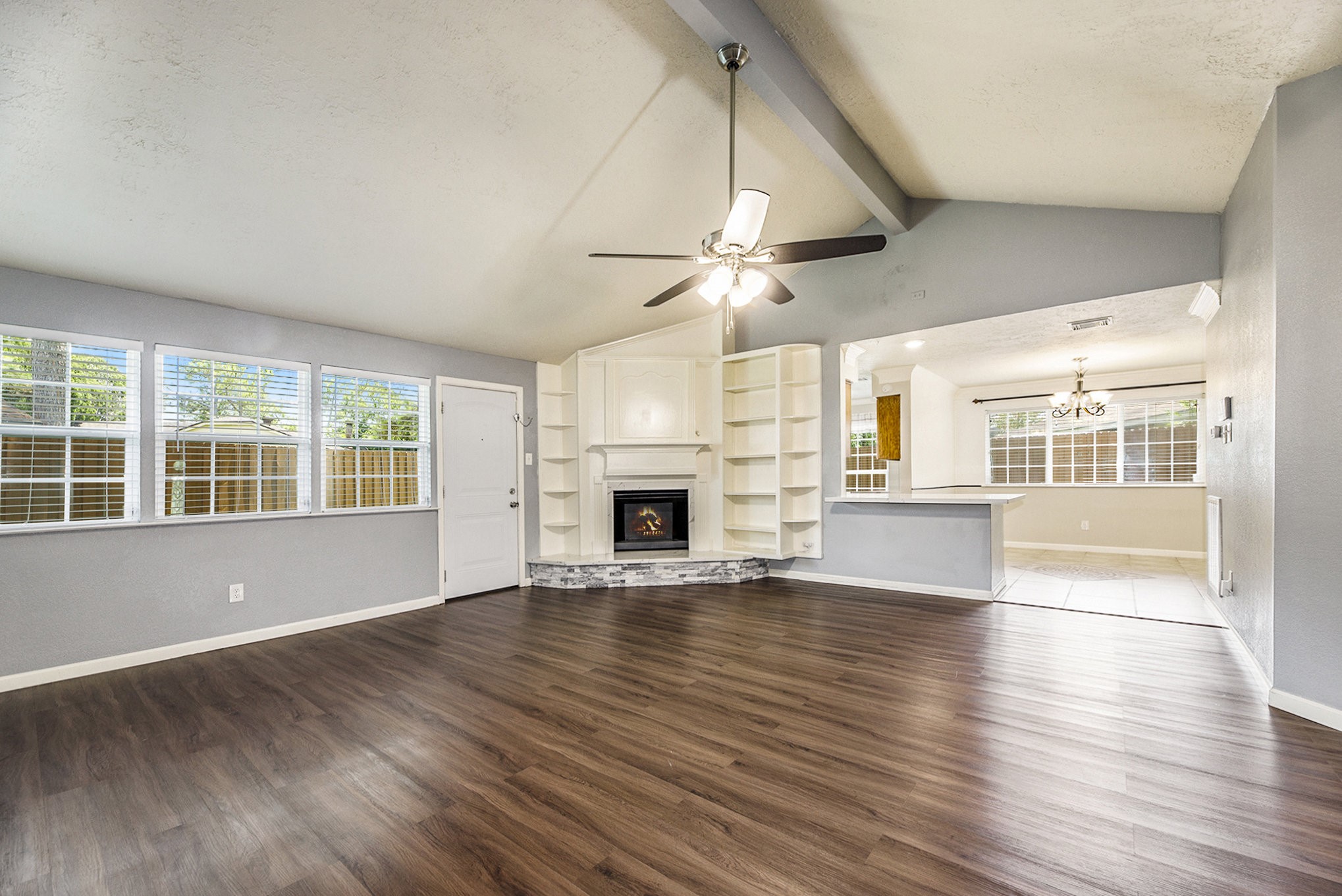 2539 Cobblers Way Friendswood, TX 77546 - Photo 4 of 19 an empty room with wooden floor fireplace and windows