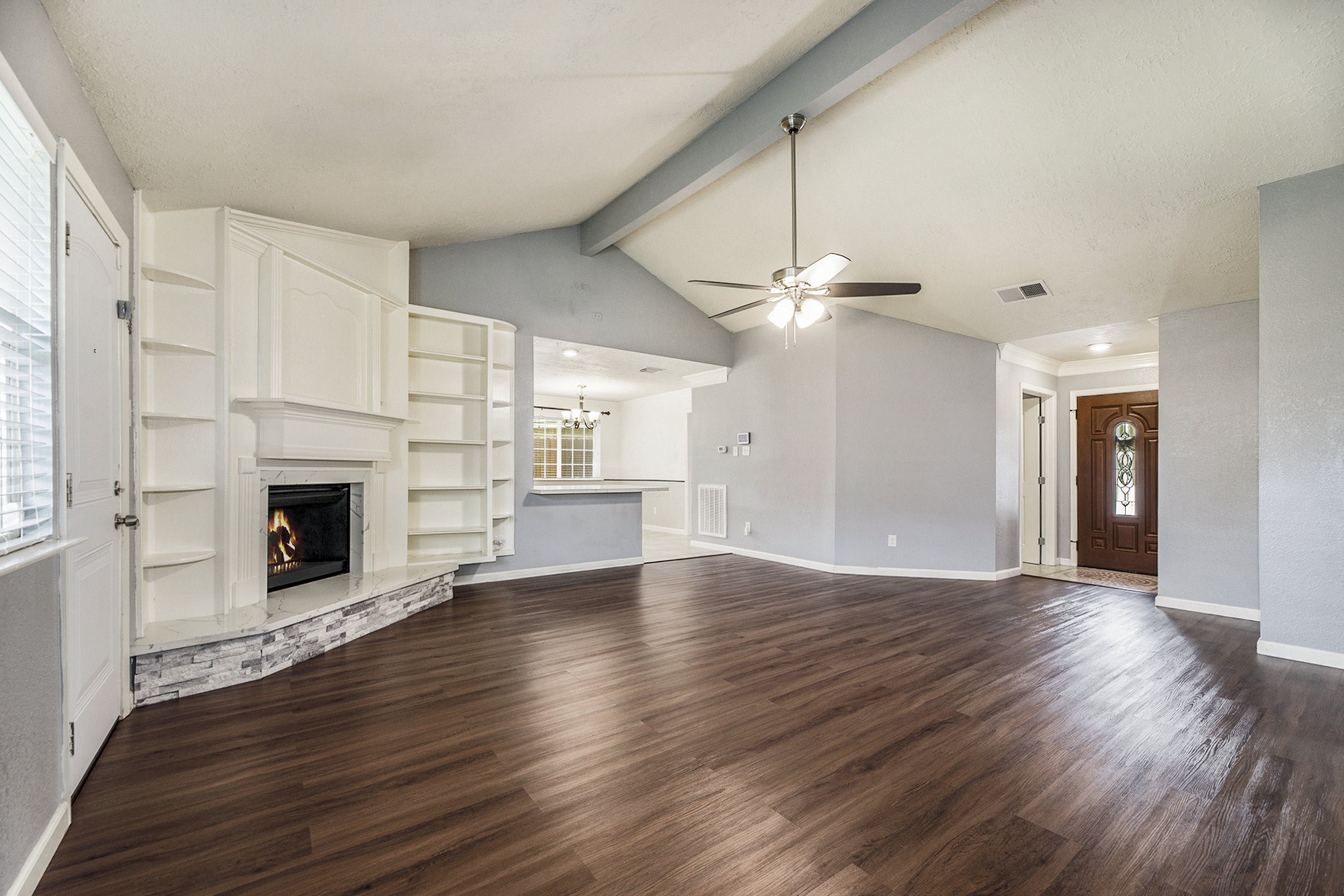 2539 Cobblers Way Friendswood, TX 77546 - Photo 6 of 19 a view of an empty room with wooden floor fireplace and a window