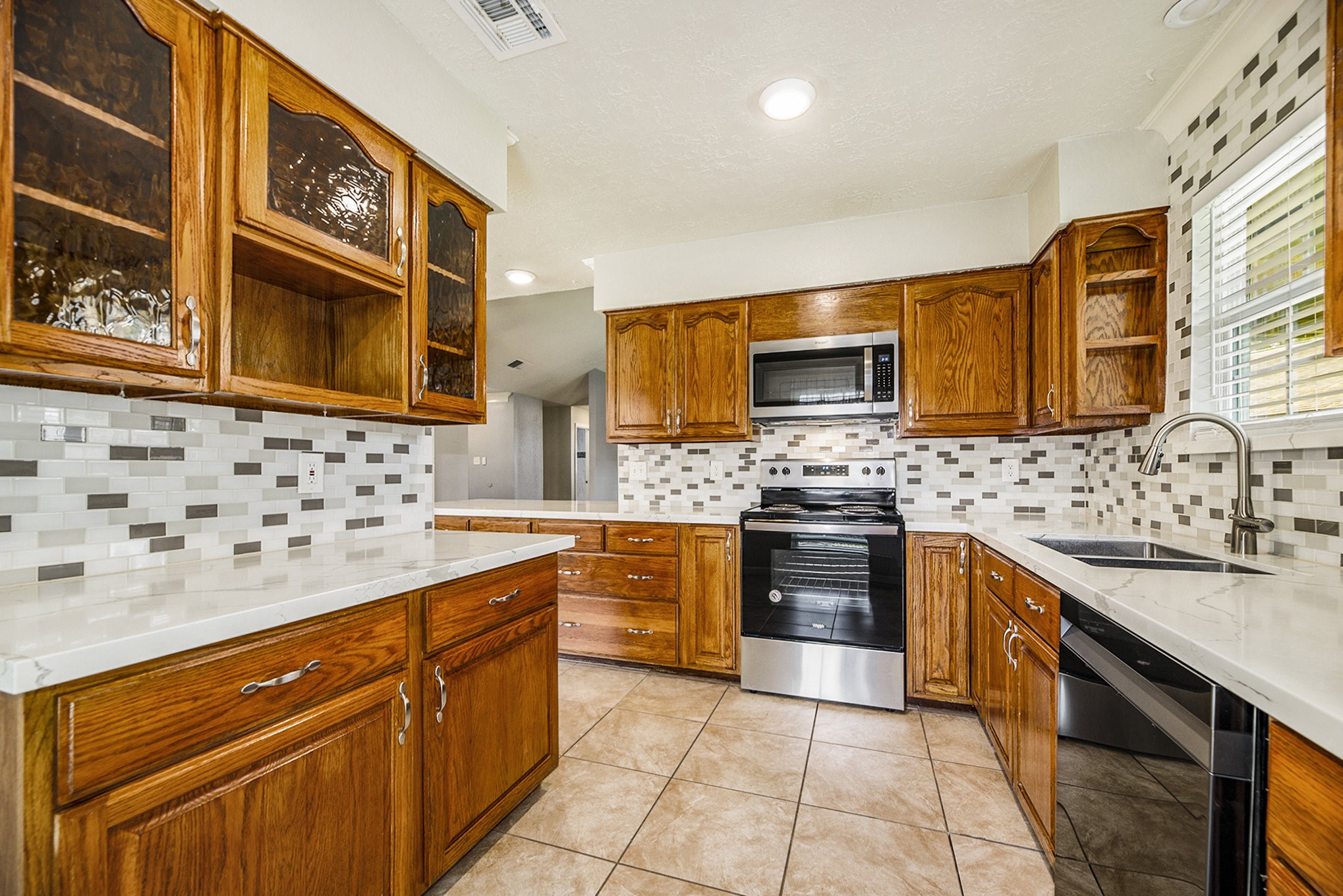 2539 Cobblers Way Friendswood, TX 77546 - Photo 9 of 19 a kitchen with stainless steel appliances granite countertop a sink stove and microwave