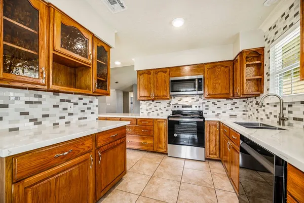 a kitchen with stainless steel appliances granite countertop a sink stove and microwave
