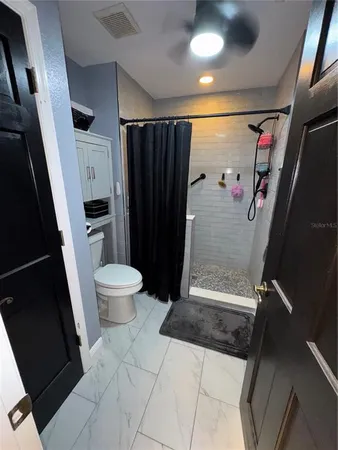 a bathroom with a toilet and a shower