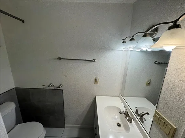 a bathroom with a sink a toilet and mirror