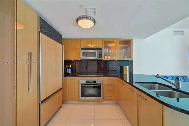 a kitchen with stainless steel appliances granite countertop a sink a stove and a refrigerator