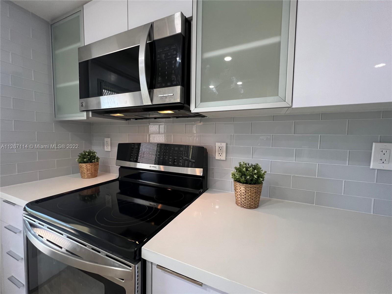 a kitchen with a microwave and potted plant