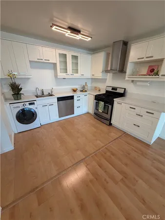 a kitchen with a stove a sink and cabinets