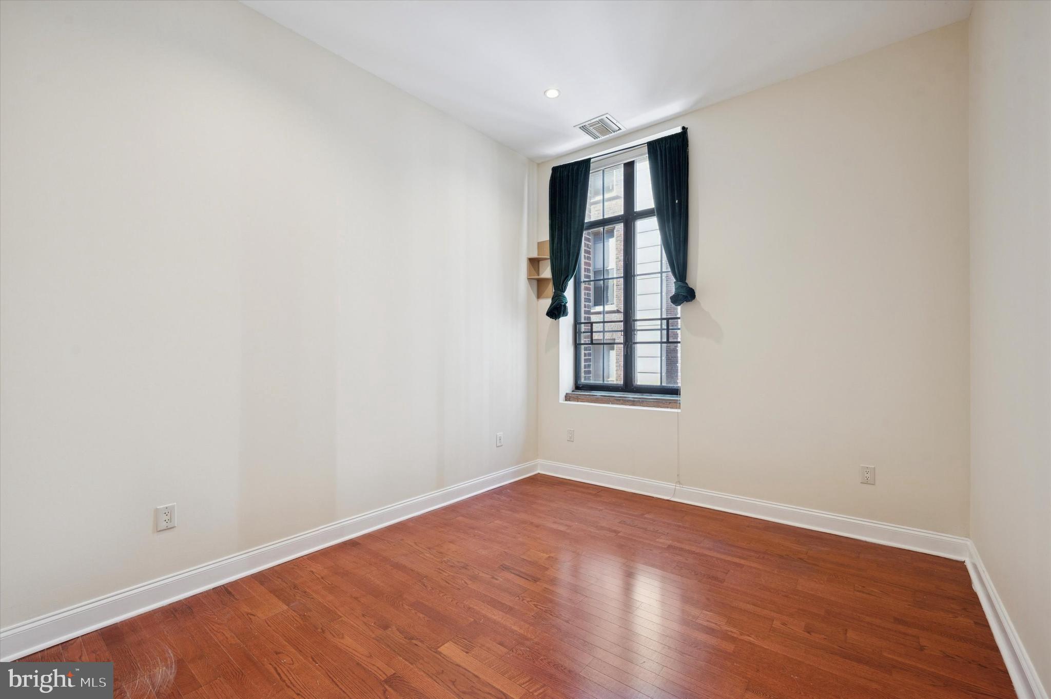 1601 Spring Garden Street, Unit 205 Philadelphia, PA 19130 - Photo 11 of 17 an empty room with wooden floor and windows