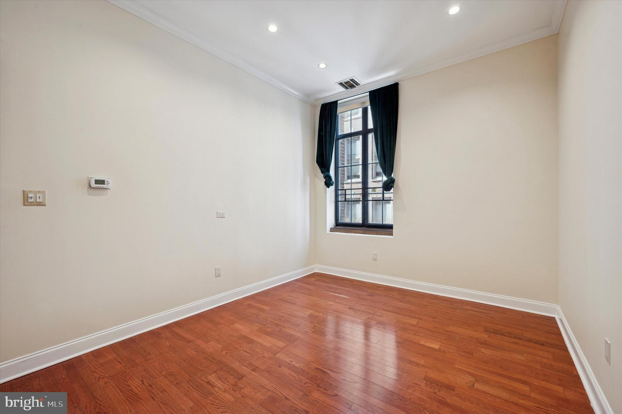1601 Spring Garden Street, Unit 205 Philadelphia, PA 19130 - Photo 6 of 17 an empty room with windows and closet
