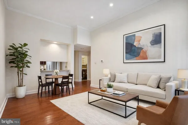 a living room with furniture a dining table with wooden floor and a potted plant