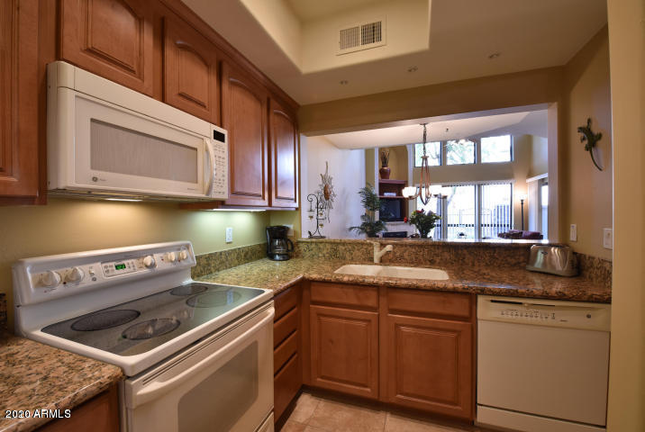 7641 East Indian Bend Road Scottsdale, AZ 85250 - Photo 4 of 19 a kitchen with granite countertop a sink and a stove