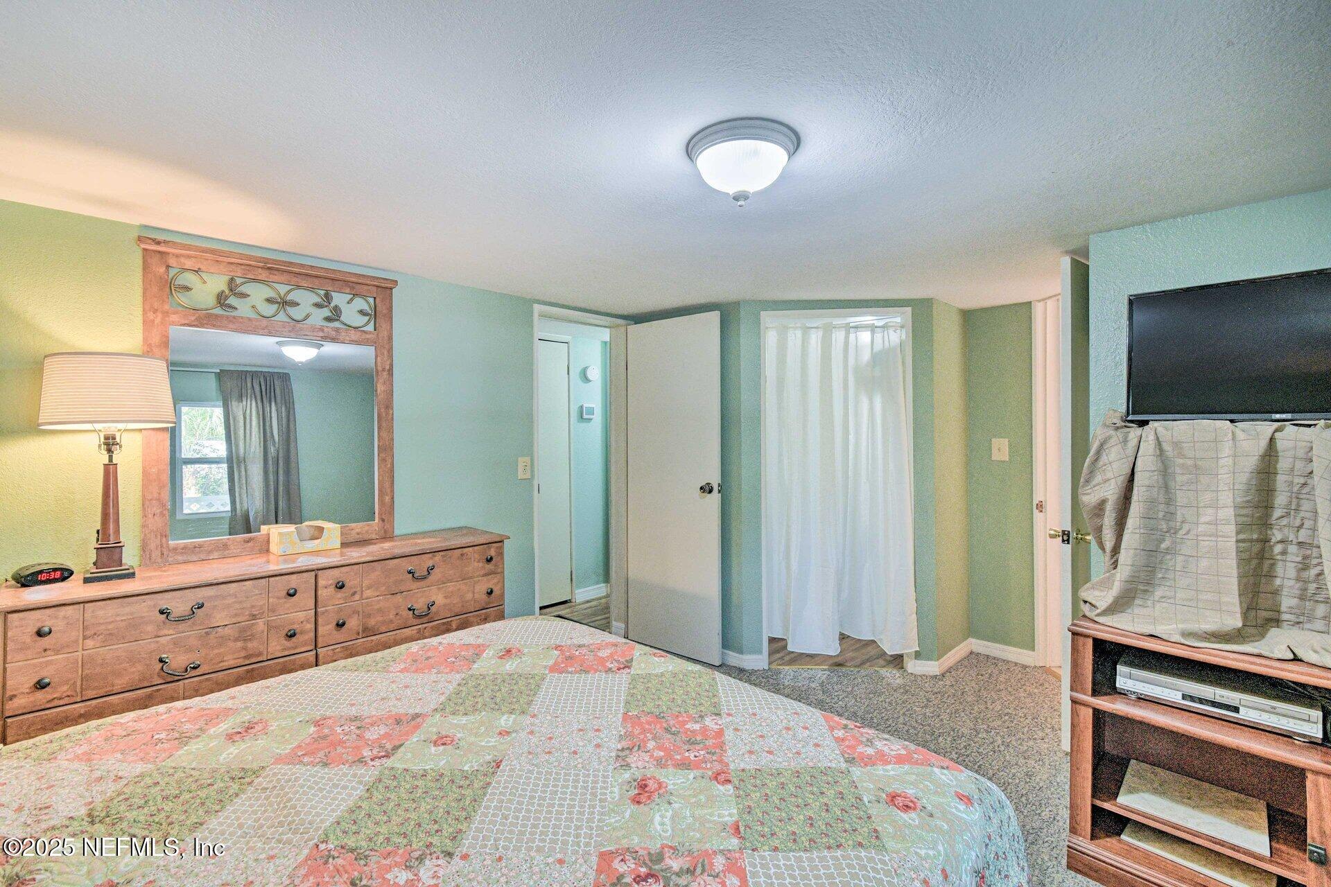 118 Riverside Avenue Satsuma, FL 32189 - Photo 12 of 27 a bedroom with a bed and a flat screen tv