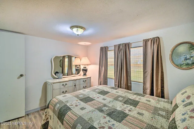 a bedroom with a bed and a dresser with mirror