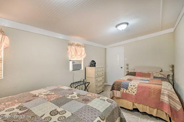 a bedroom with two bed and a window