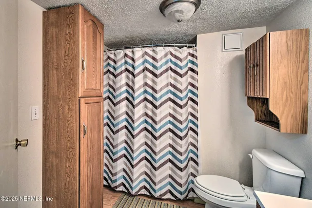 a white toilet sitting next to a shower curtain